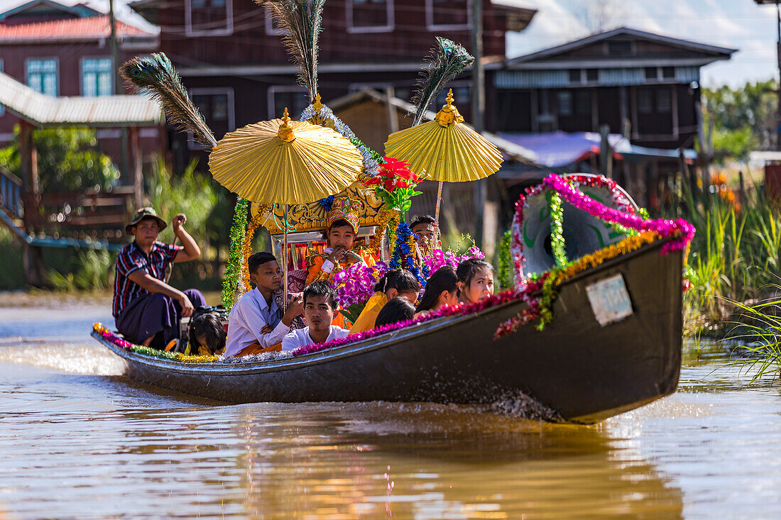 Prozession und Festakt zur buddhistischen Mönchsweihe eines jungen Burmesen auf einem Langboot im Inle-See, Myanmar