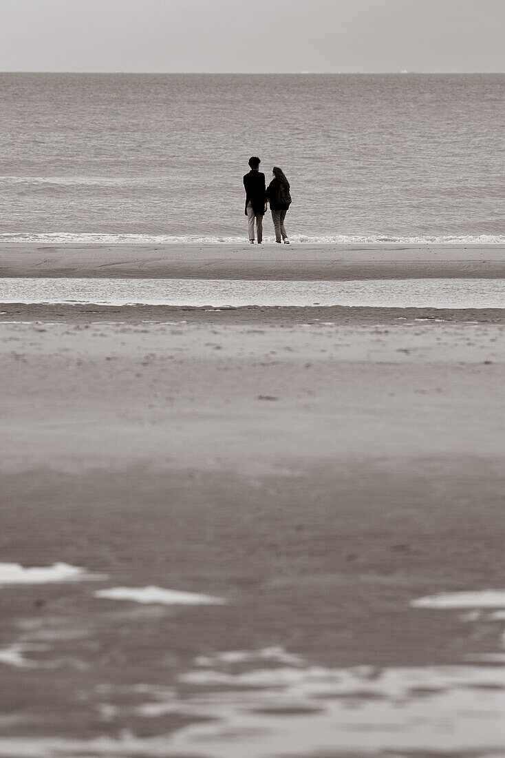 Paar mit Blick auf das Meer in Ostende, Belgien.