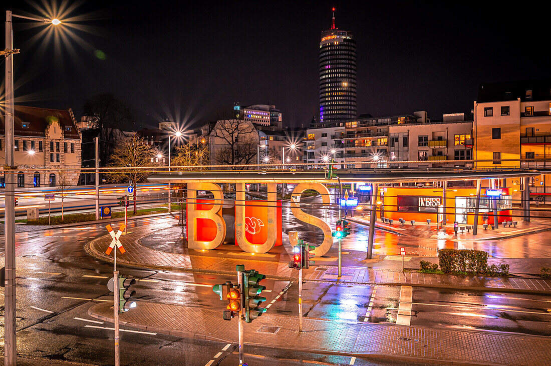 Blick auf den Busbahnhof und den Jentower im Hintergrund von Jena mit Langzeitbelichtung einer Straßenbahn in der Nacht, Jena, Thüringen, Deutschland