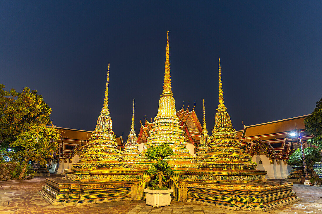 Chedis im buddhistischen Tempel Wat Pho in der Abenddämmerung, Bangkok, Thailand, Asien   
