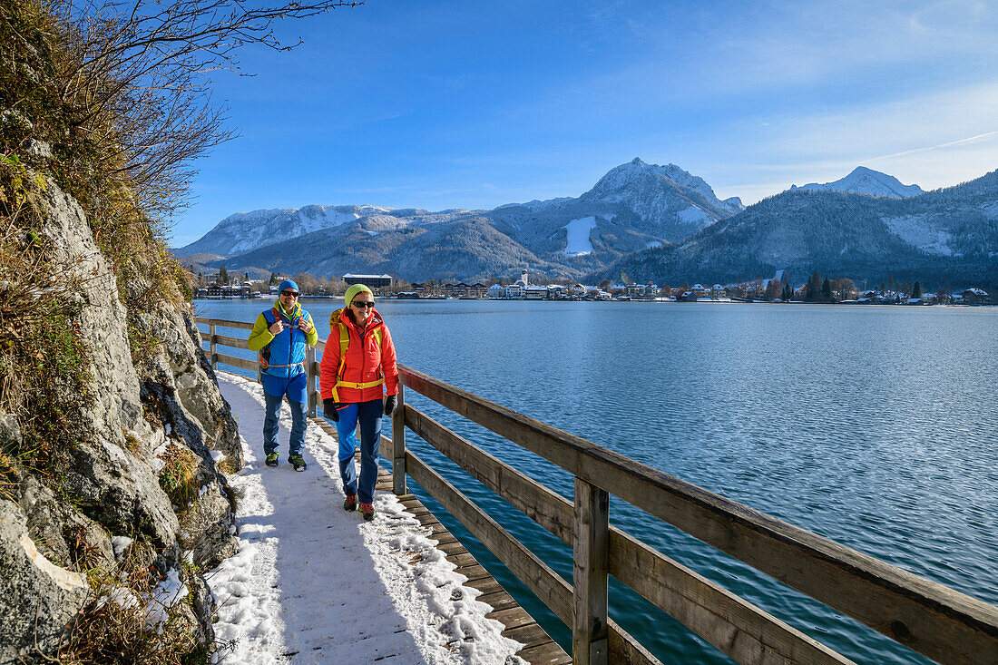 Mann und Frau wandern am Bürglsteig mit Strobl im Hintergrund, Bürglsteig, Strobl, Wolfgangsee, Salzkammergut, Salzkammergutberge, Salzburg, Österreich