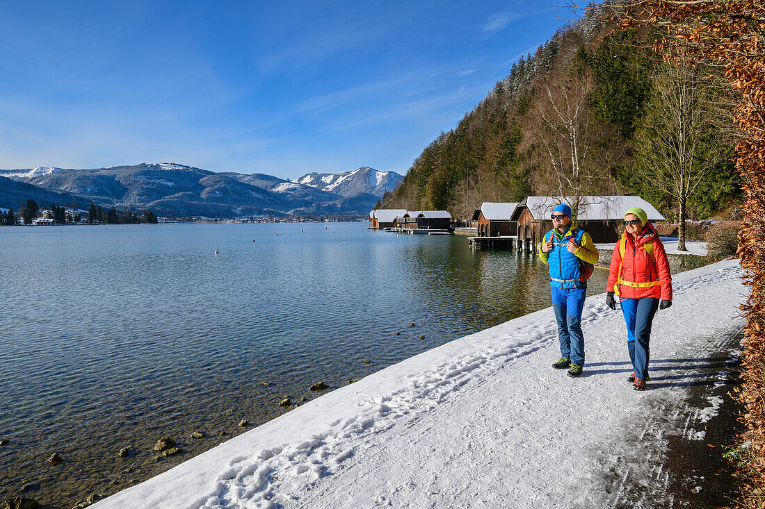 Man and woman hiking on the Bürglsteig with boathouses and Wolfgangsee in the background, Bürglsteig, Strobl, Wolfgangsee, Salzkammergut, Salzkammergut Mountains, Salzburg, Austria
