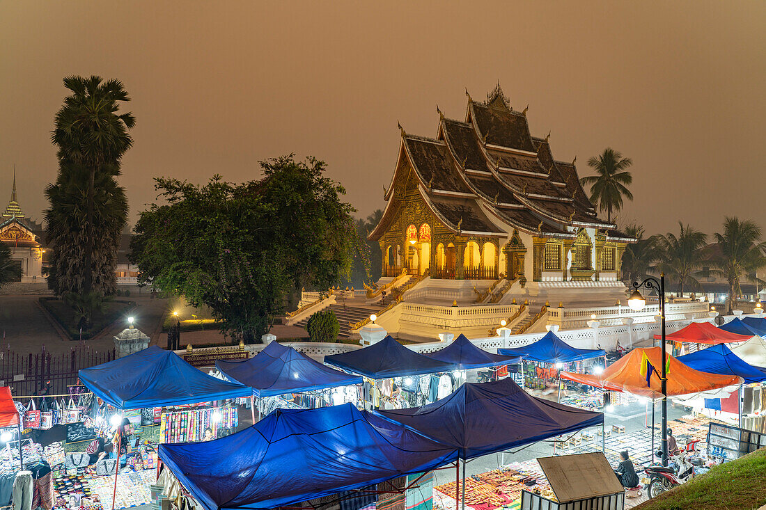 Nachtmarkt und der Tempel Haw Pha Bang des Königspalast in Luang Prabang in der Abenddämmerung, Laos, Asien 