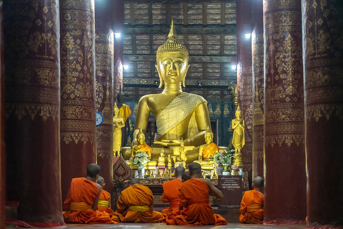 Mönche beim Gebet vor dem grossen Buddha im Tempel Wat Pak Khan Khammungkhun, Luang Prabang, Laos, Asien