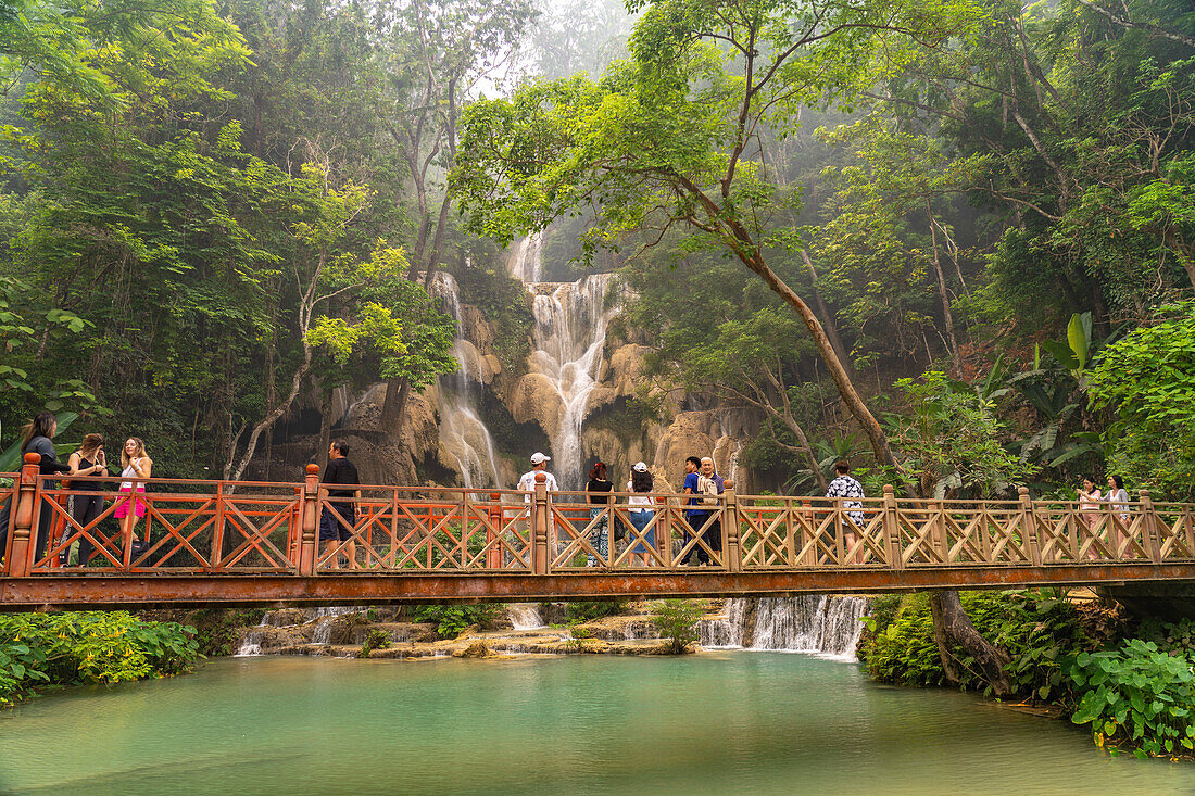 Touristen auf der Brücke am Kuang Si Wasserfall bei Luang Prabang, Laos, Asien