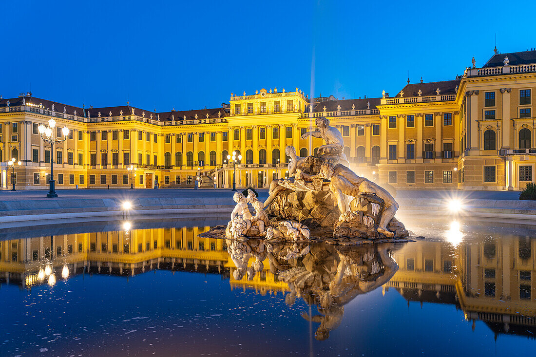 Brunnen im Ehrenhof von Schloss Schönbrunn in der Abenddämmerung, UNESCO Welterbe in Wien, Österreich, Europa  
