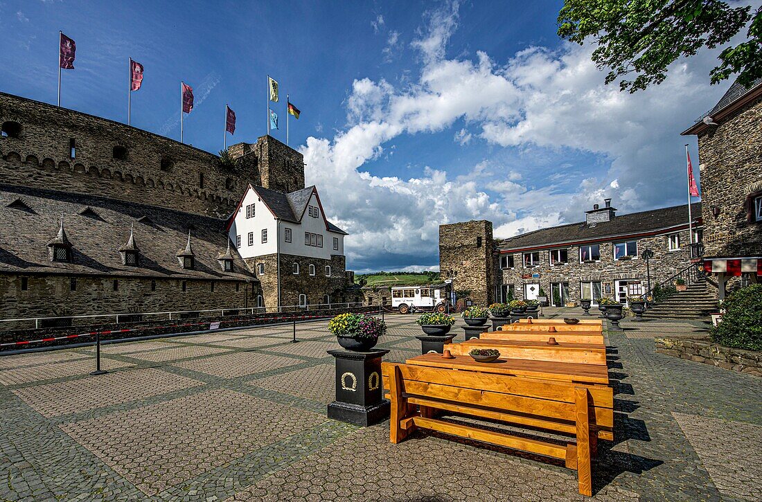 View from the flower-decorated square in front of Hotel Schloss Rheinfels to the battlements of Rheinfels Castle, the clock tower and the entrance area of the castle, St. Goar, Upper Middle Rhine Valley, Rhineland-Palatinate, Germany
