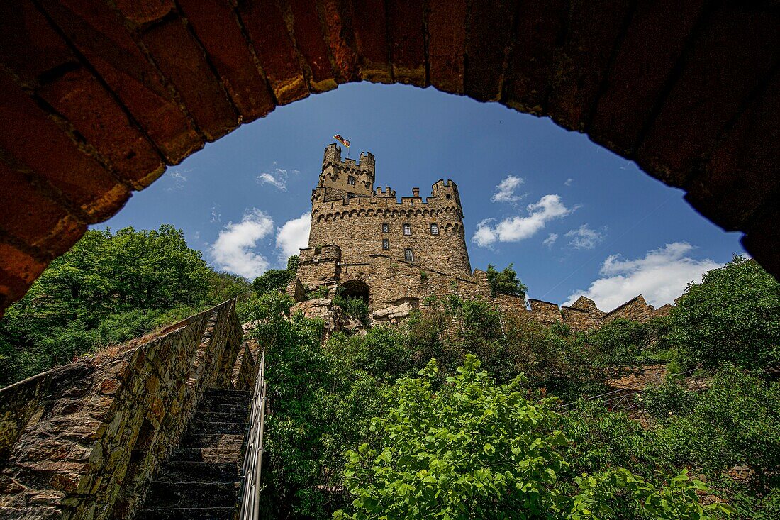 Sooneck Castle, view through an arch of the outer bailey to the main bailey with keep and waving flag, Niederheimbach, Upper Middle Rhine Valley, Rhineland-Palatinate, Germany