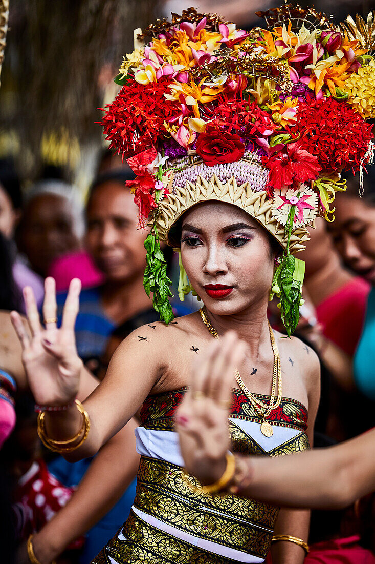 A young woman in traditional dress dancing for the festival Gulangan in Karangasem Bali Indonesia