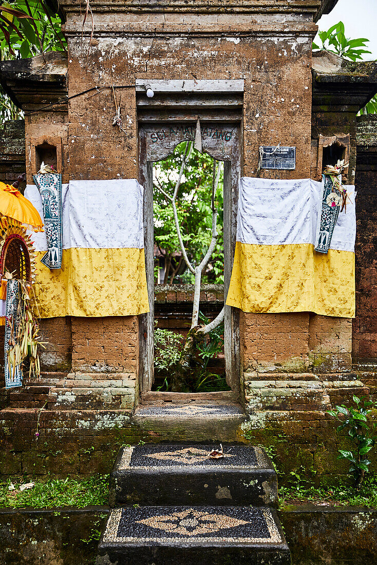 The front door of a family compound in a village in Gianyar Bali Indonesia. Over the door are the words for "Welcome".