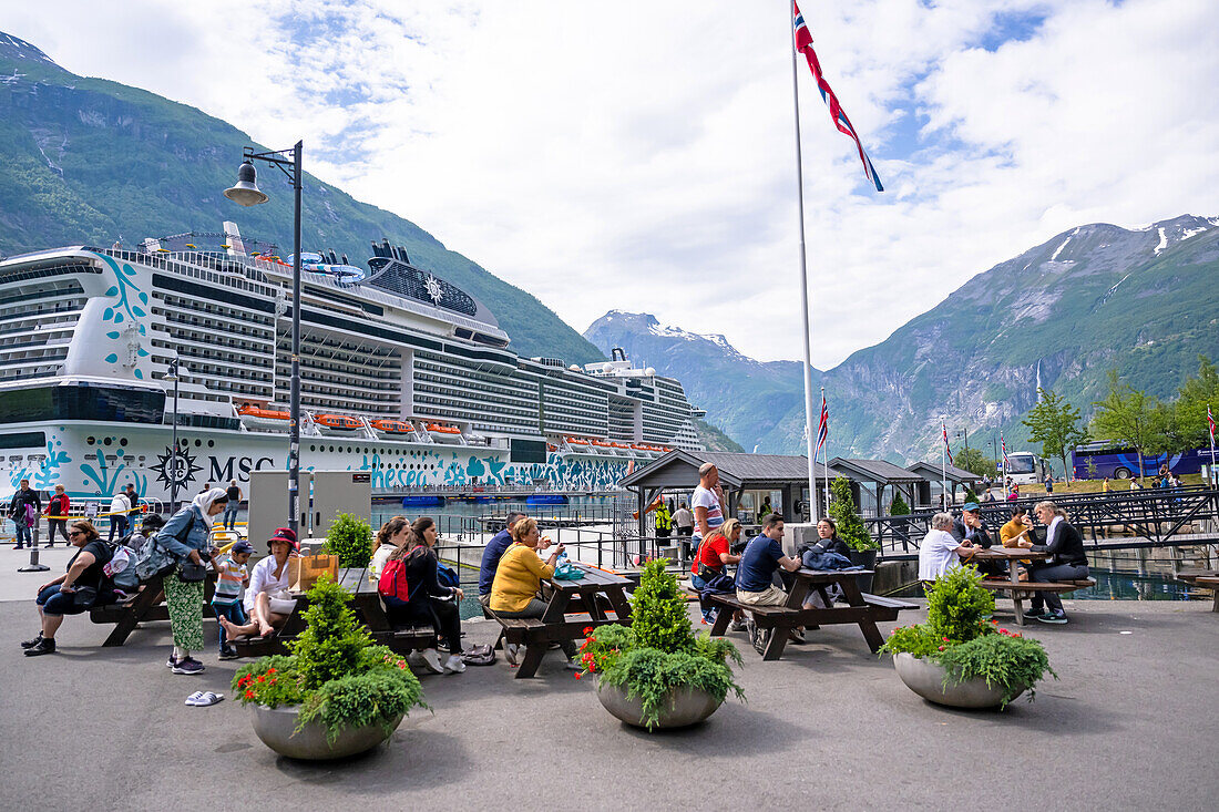 Tourists on benches in front of a cruise ship in Geiranger, Unesco World Heritage, Fjord, Moere and Romsdal