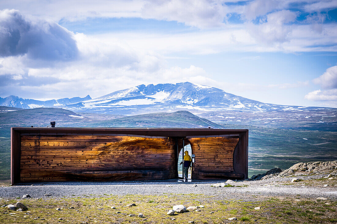 A man with a camera walks into Snoehetta Viewpoint, Hjerkinn, Dovre, Visitor Center wild Reindeer, Dovrefjell-Sunndalsfjella National Park, Tverrfjellhytja, Oppland Region, Norway
