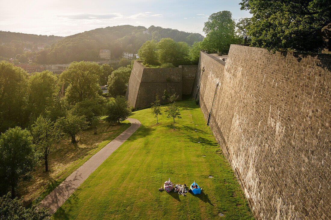 young people relax in Fatboys in front of the defensive wall of the Sparrenburg, Bielefeld, North Rhine-Westphalia, Germany, Europe