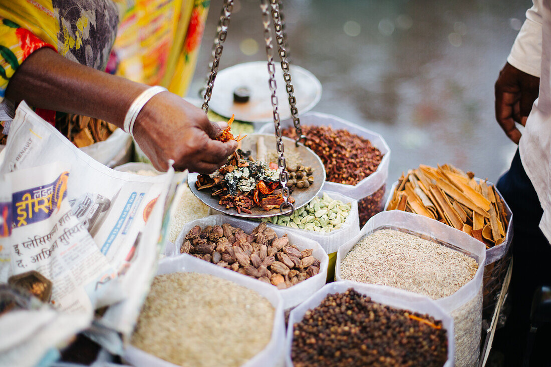 Pune, Indien, Gewürze werden gewogen und auf dem Markt an Käufer verkauft