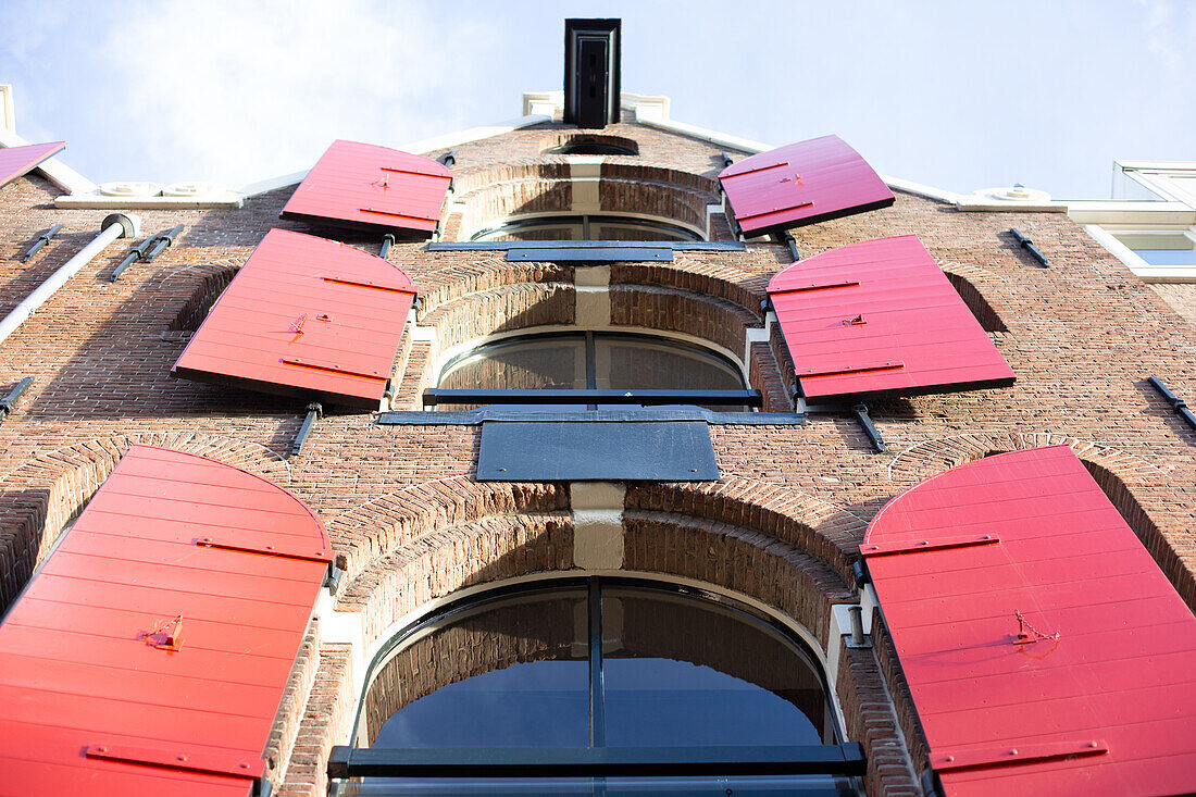 Amsterdam, Niederlande, Häuser mit roten Holzjalousien