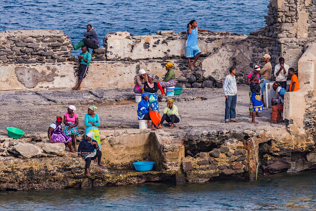 Frauen und Männer warten auf die Ankunft eines Fischerbootes am improvisierten Hafen, Kapverdische Inseln