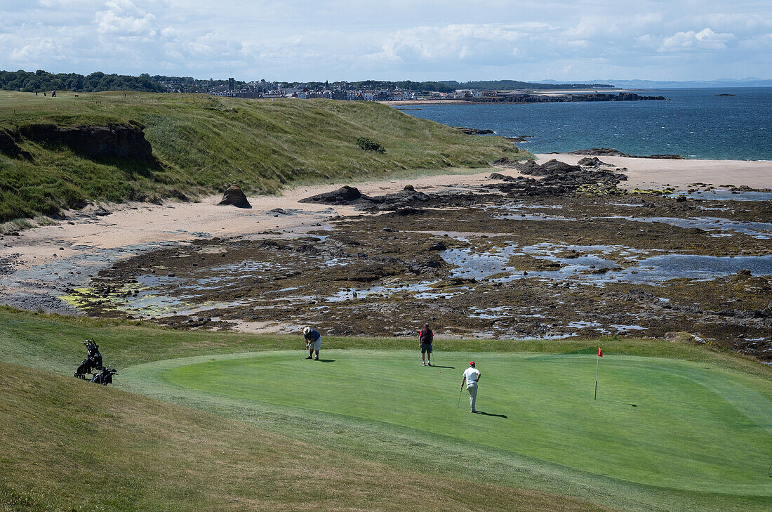 Golfers at the 13th green of Glen Golf Club, with North Berwick in the background, East Lothian, Scotland, United Kingdom