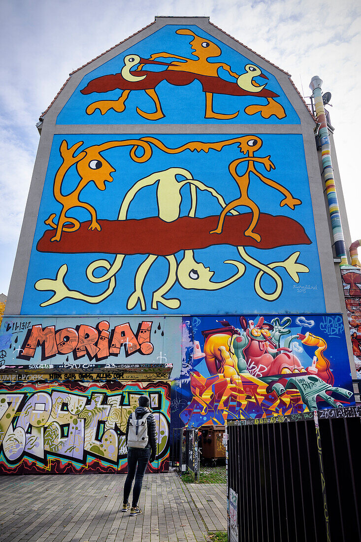 Junge Frau begutachtet riesige Wandbilder (Graffiti) an Kunsthofpassage Dresden, Freistaat Sachsen, Deutschland, Europa