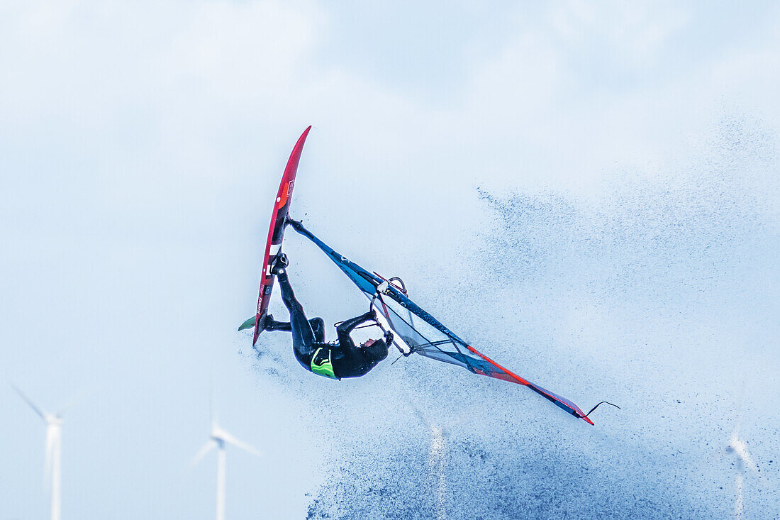 Windsurfer jumping in front of wind turbines, Baltic Sea, Schleswig-Holstein, Germany