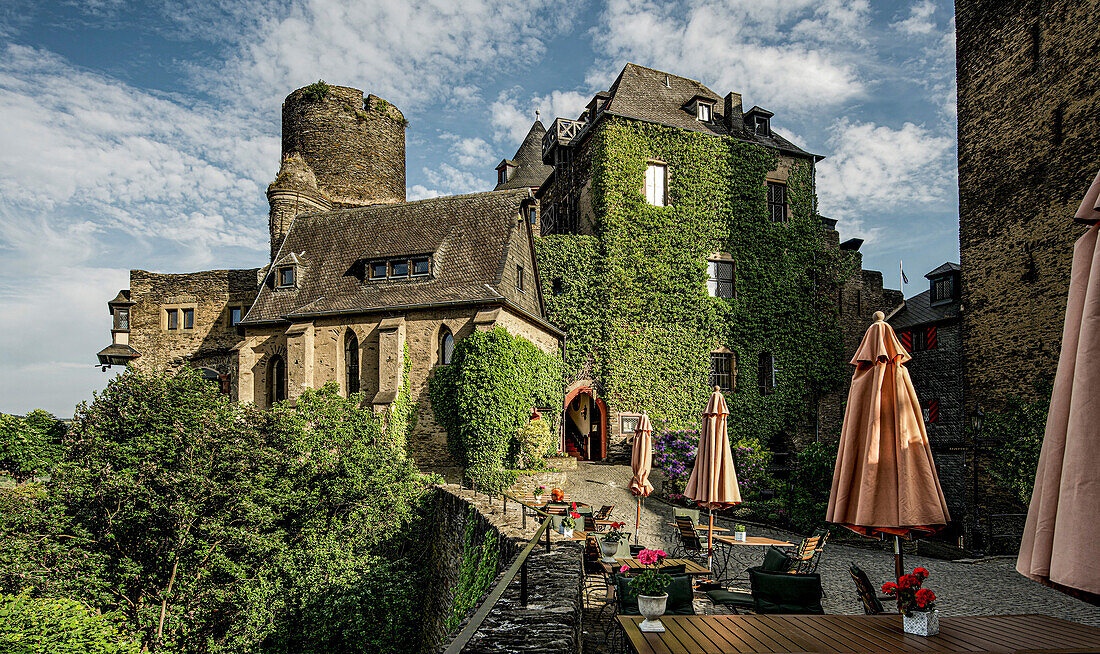 Inner courtyard of the Schönburg in the evening light with outdoor gastronomy, view of the hotel building, Babarossa Tower and Gate Tower, Oberwesel, Upper Middle Rhine Valley, Rhineland-Palatinate, Germany