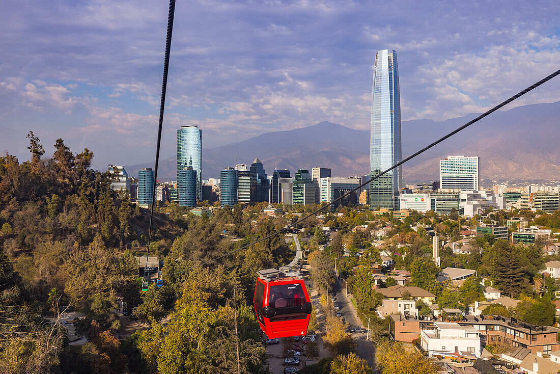 Spektakulärer Blick auf den Wolkenkratzer Gran Torre Santiago sowie die Stadt Santiago de Chile vor den Anden aus der Seilbahn auf den Cerro San Cristobal, Chile, Südamerika