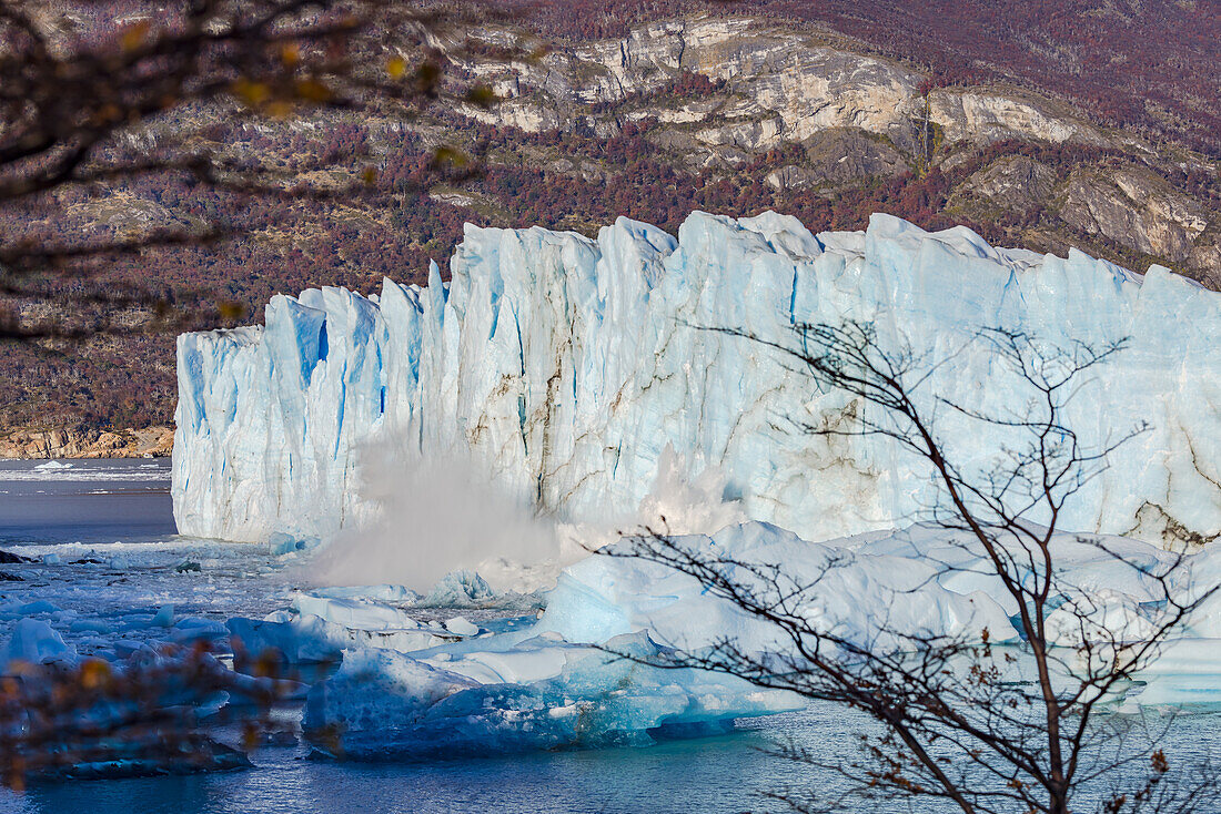 A large mass of ice breaks off at the edge with splashing water at the Perito Moreno Glacier, Los Glaciares National Park, Argentina, Patagonia