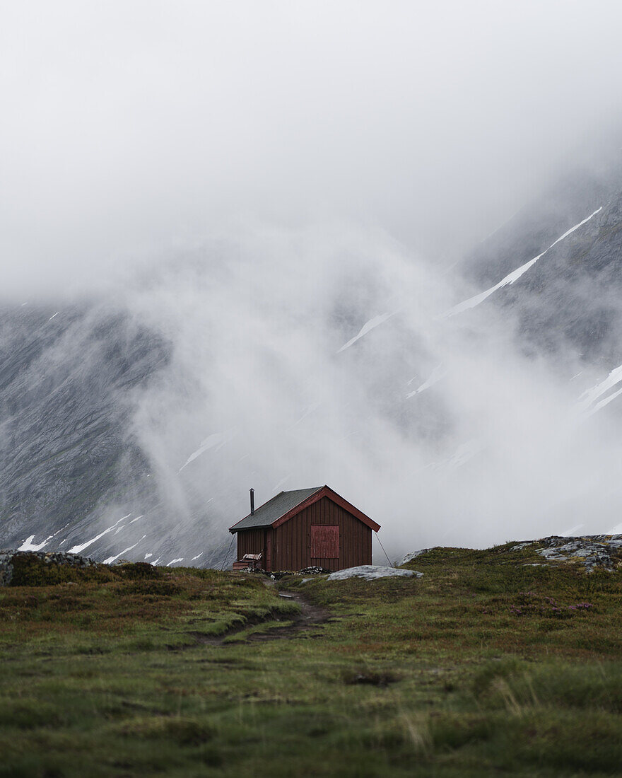 Wooden cabin in the foggy mountains of Norway