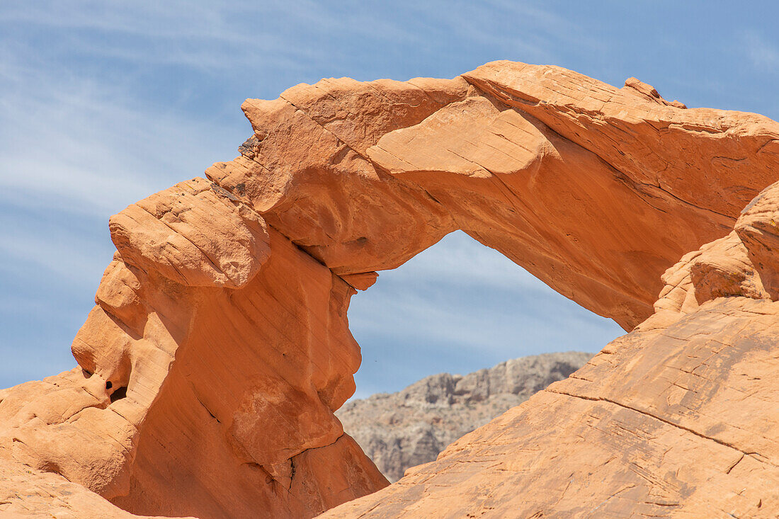 Blick auf ein Berg durch Felsbogen Atlatl Rock im Valley of Fire, Nevada, USA