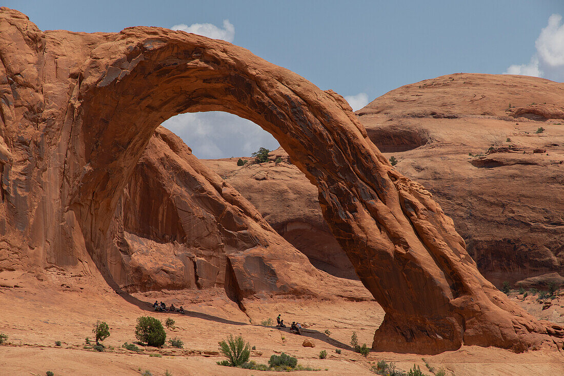 View of Corona Arch against a blue sky.