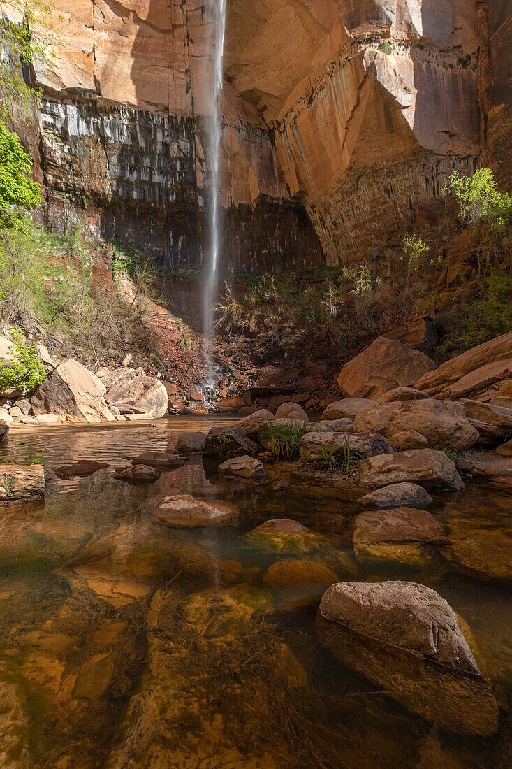 Kleiner Wasserfall mit kleinem See und Steinen im Vordergrund. Zion Nationalpark, Utah, USA