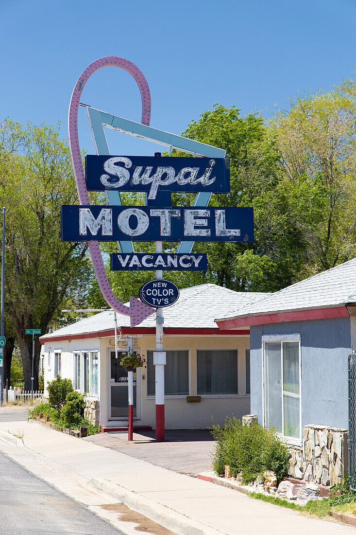 Altes Motel Schild 60er Jahre steht an Straße. Kleine Bungalows. Route 66, USA