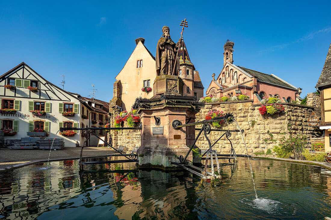 Brunnen Fontaine de Saint-Léon und St.-Leo-Kapelle in Eguisheim, Elsass, Frankreich\n