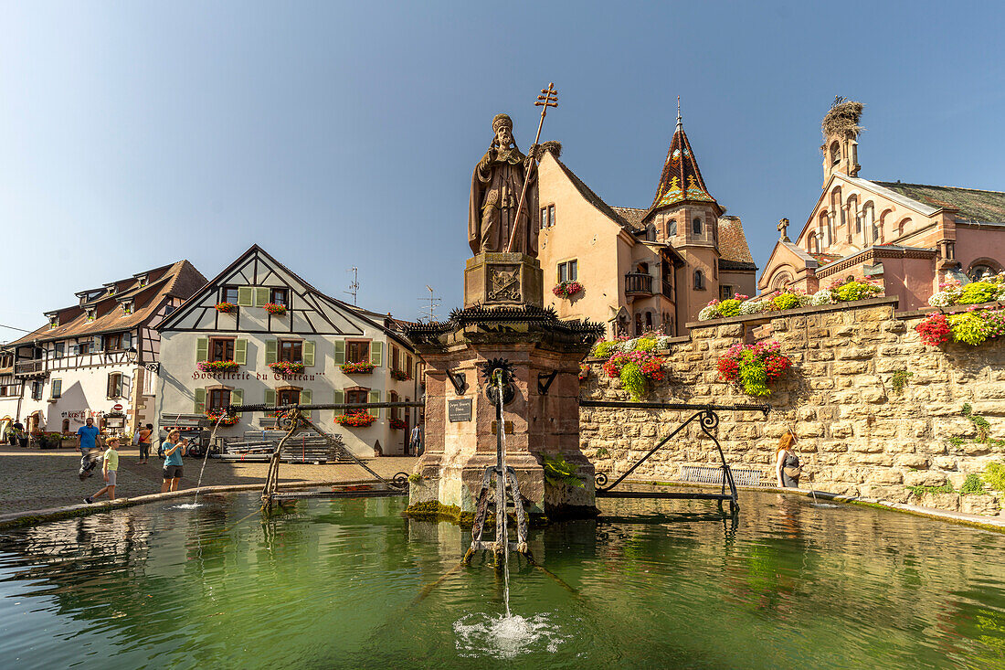 Brunnen Fontaine de Saint-Léon und St.-Leo-Kapelle in Eguisheim, Elsass, Frankreich  \n