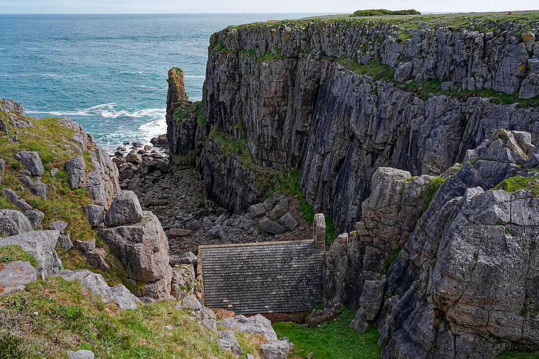 Großbritannien, Wales, Pembrokeshire, St. Govan’s Head, Blick auf Klippen und historische Kapelle St.Govan's Chapel