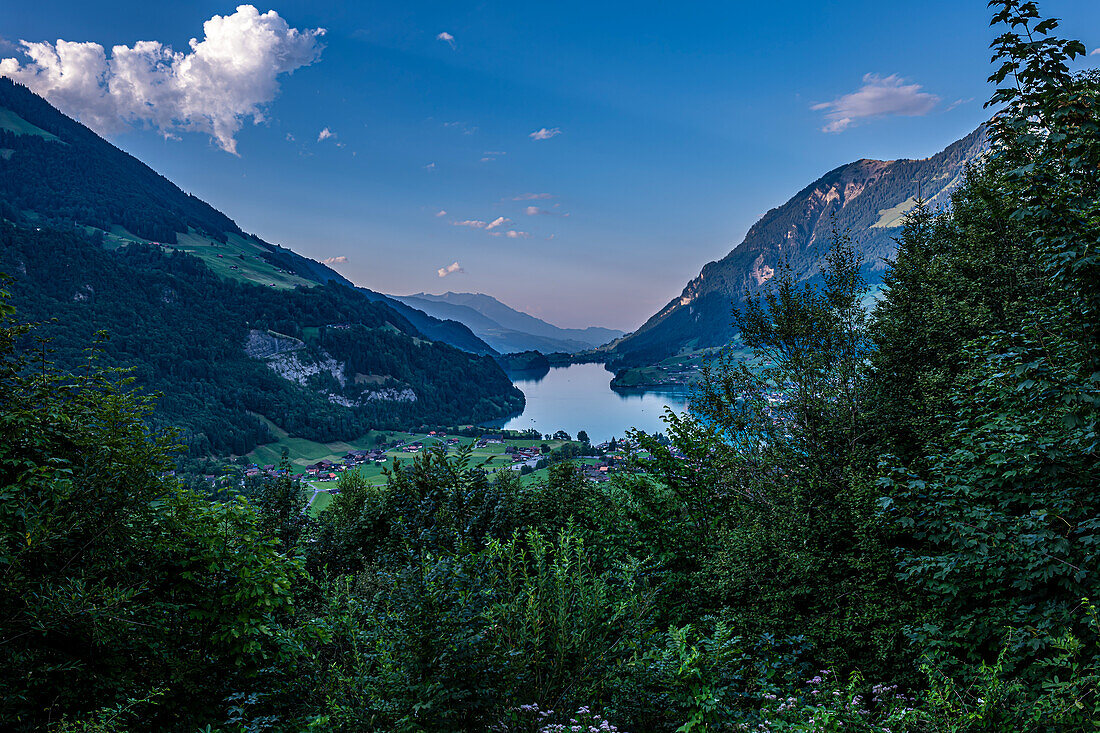 Blick über den Lungerersee und das Dorf mit Bergen bei Sonnenuntergang, Lungern, Oberwald, Schweiz.