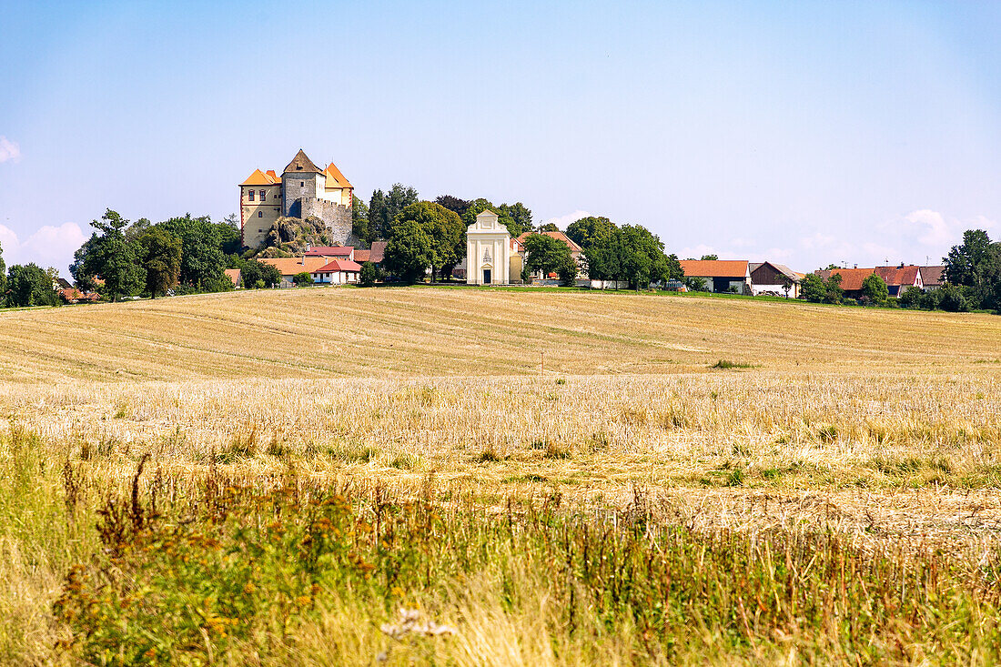 Kámen Castle in front of a harvested grain field in the Bohemian-Moravian Highlands in the Czech Republic