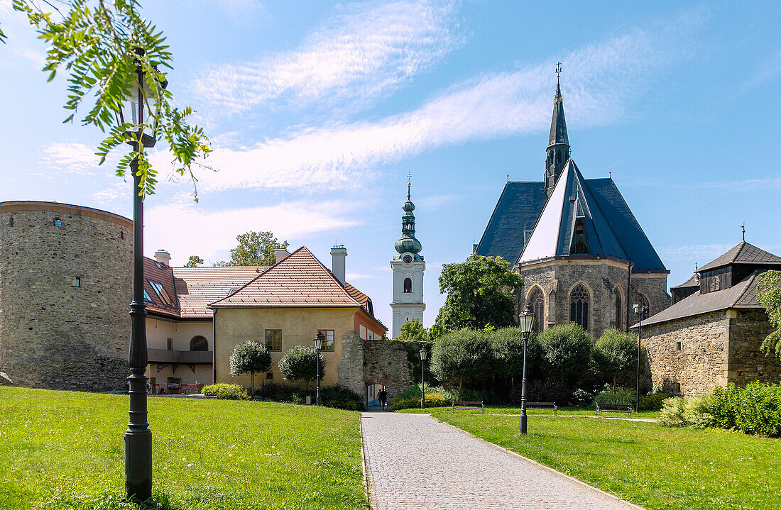 mittelalterliche Stadtbefestigung und Stadtpfarrkirche Mariä Geburt, im Hintergrund weißer Turm der Jesuitenkirche, in Domažlice in Westböhmen in Tschechien