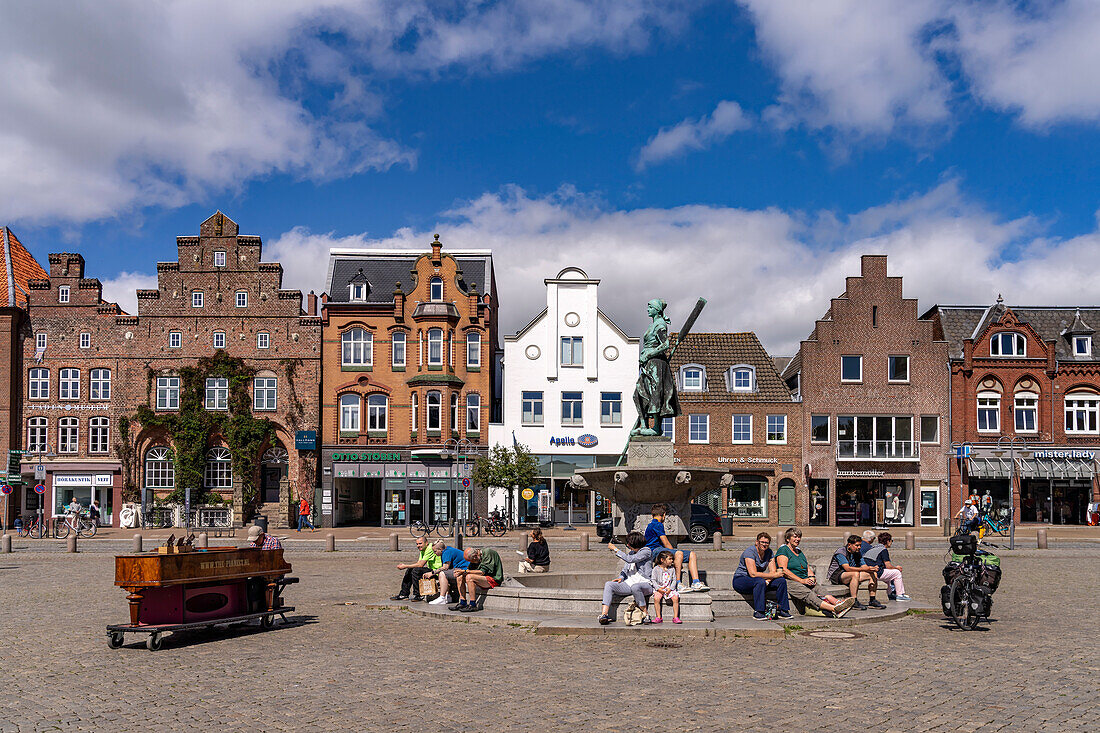 Tine statue of the Asmussen-Woldsen Monument or Tine Fountain in front of the houses of the old town at the market in Husum, Nordfriesland district, Schleswig-Holstein, Germany, Europe