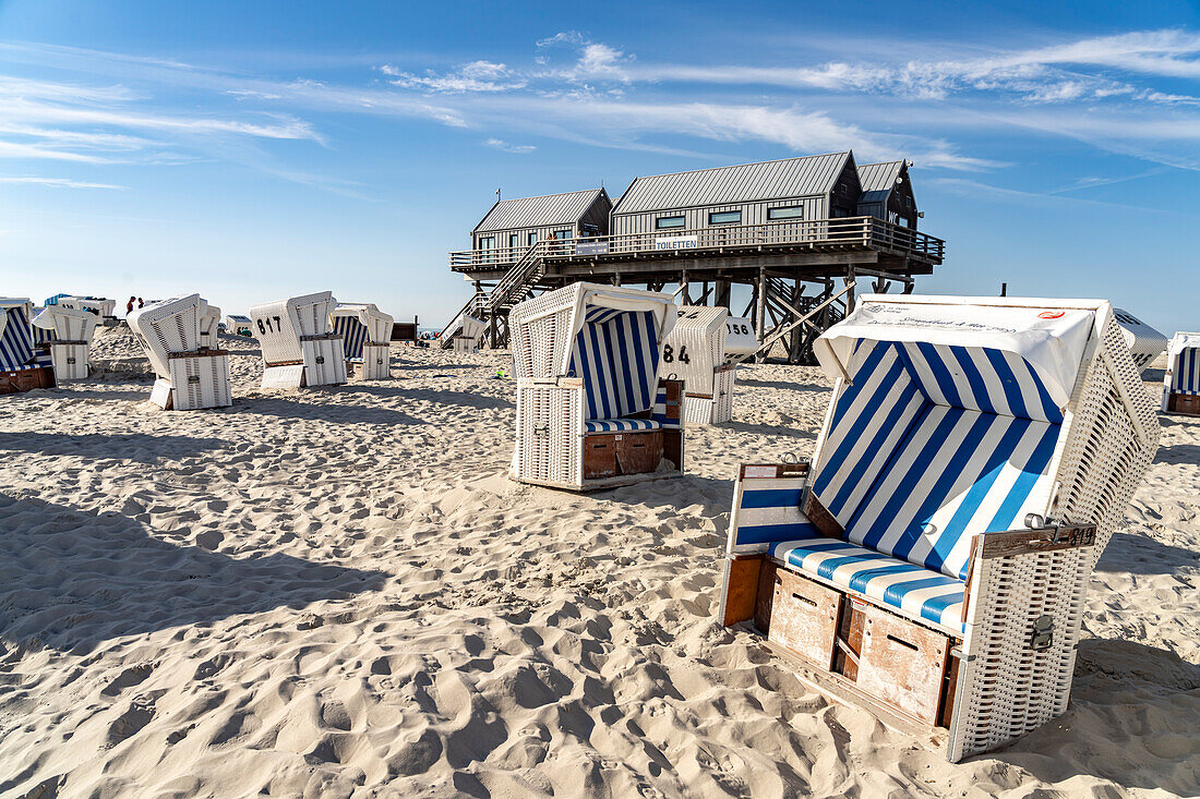 Beach chairs and stilt houses on the beach in Sankt Peter-Ording, Nordfriesland district, Schleswig-Holstein, Germany, Europe