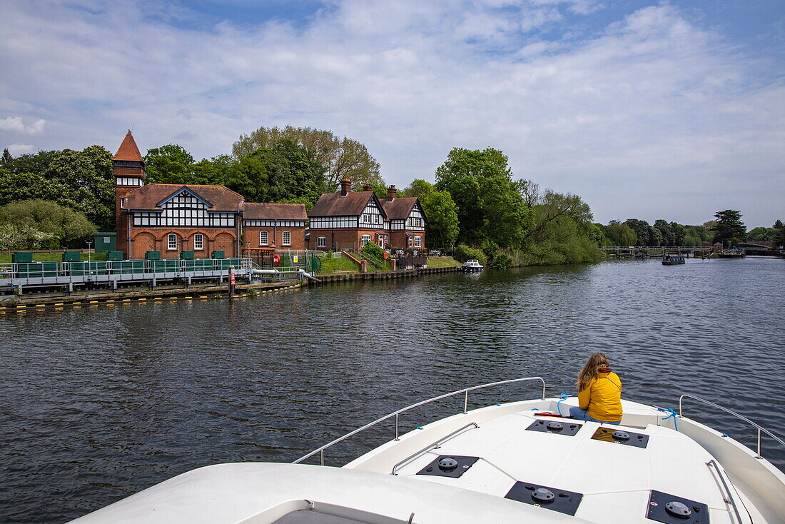 Woman on bow of Le Boat Horizon 4 houseboat on River Thames, Runnymede, Surrey, England, United Kingdom