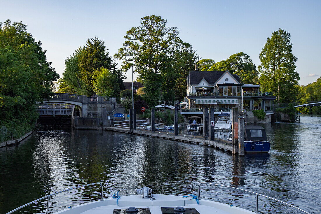 Bow of a Le Boat Horizon 4 houseboat and people enjoying dinner at the Boathouse at Boulters Lock along the River Thames, Maidenhead, Berkshire, England, United Kingdom