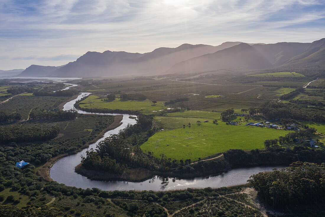 Luftaufnahme vom Fluss Kleinrivier mit den Bergen des Maanschynkop-Naturreservats dahinter, Stanford, Westkap, Südafrika
