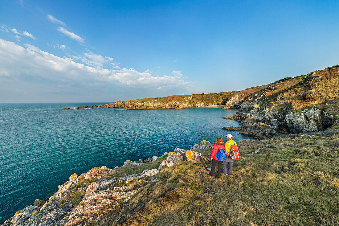 Mann und Frau beim Wandern blicken auf Felsküste, Cap-Sizun, GR 34, Zöllnerweg, Bretagne, Frankreich