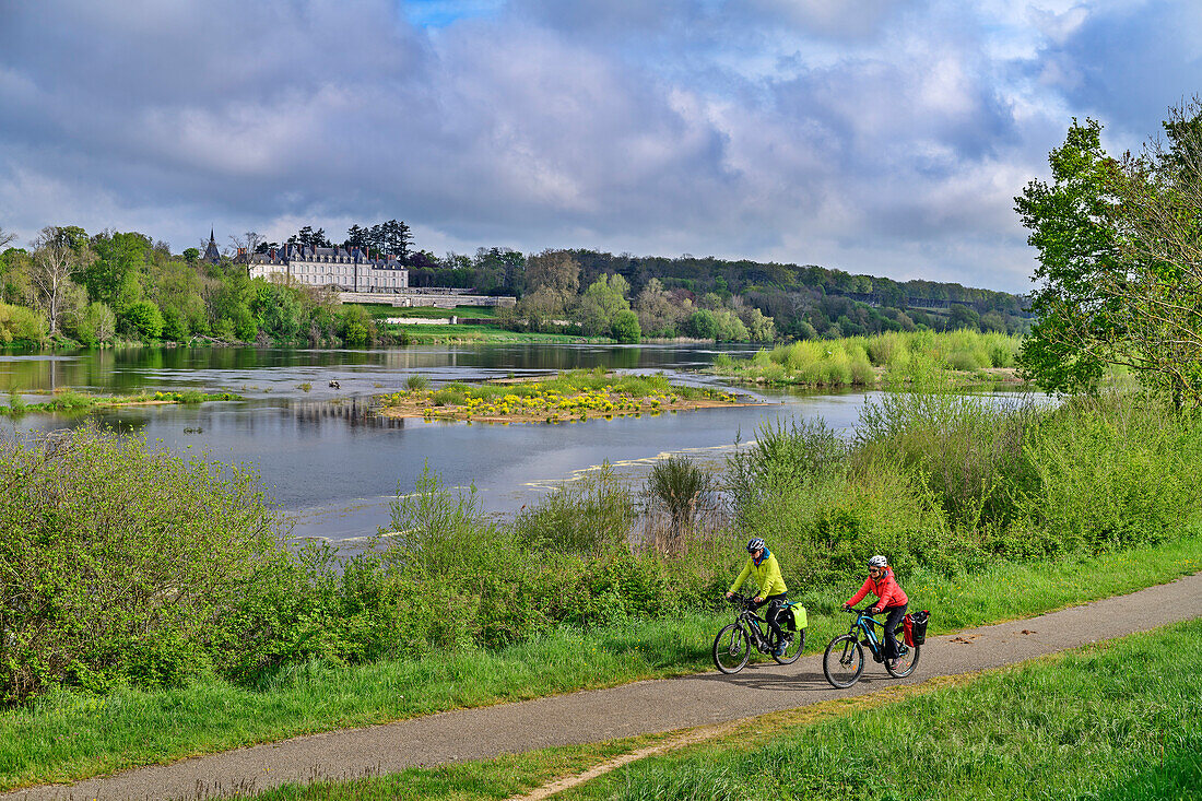 Mann und Frau beim Radfahren auf dem Loire-Radweg mit Blick über das Loiretal auf das Château de Menars, Loire-Schlösser, Loiretal, UNESCO Welterbe Loiretal, Frankreich