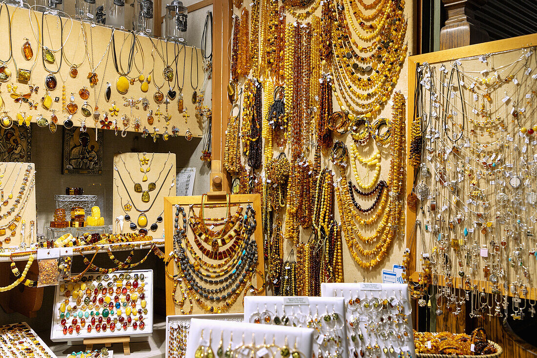 Bernsteinschmuck und Heiligenbilder aus Silber am Verkaufsstand in den Tuchhallen (Sukienice) im Inneren am Rynek Glówny in der Altstadt von Kraków in Polen