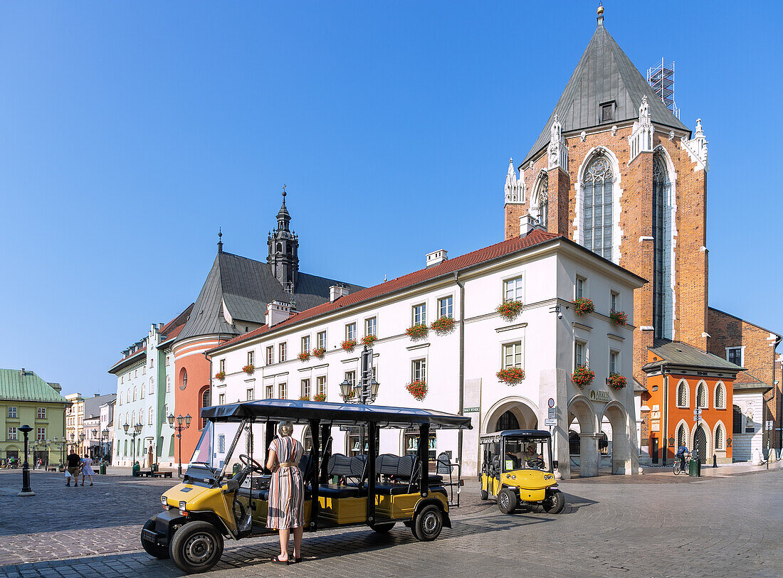 Mały Rynek with Electric Meleks (Melexi) and St. Mary's Church (Kościół Mariacki) in the morning light in the Old Town of Kraków in Poland