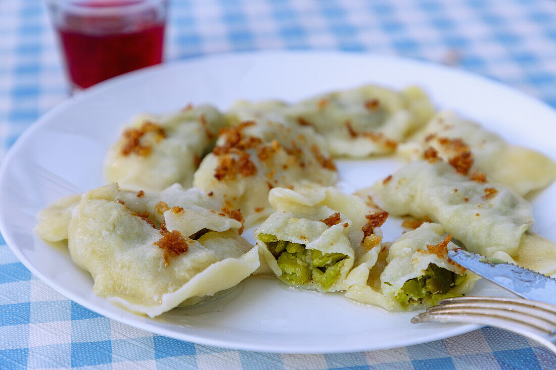 Pirogi, gefüllt mit Erbsen und Wasabi, und Kompot, serviert in Wieliczka in Kleinpolen in Polen