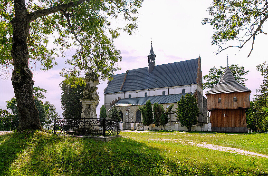 gotische Pfarrkirche St. Peter und Paul (Kościół pw. śś. Piotra i Pawła) und freistehender Glockenturm aus Holz in Beszowa in der Woiwodschaft Świętokrzyskie in Polen
