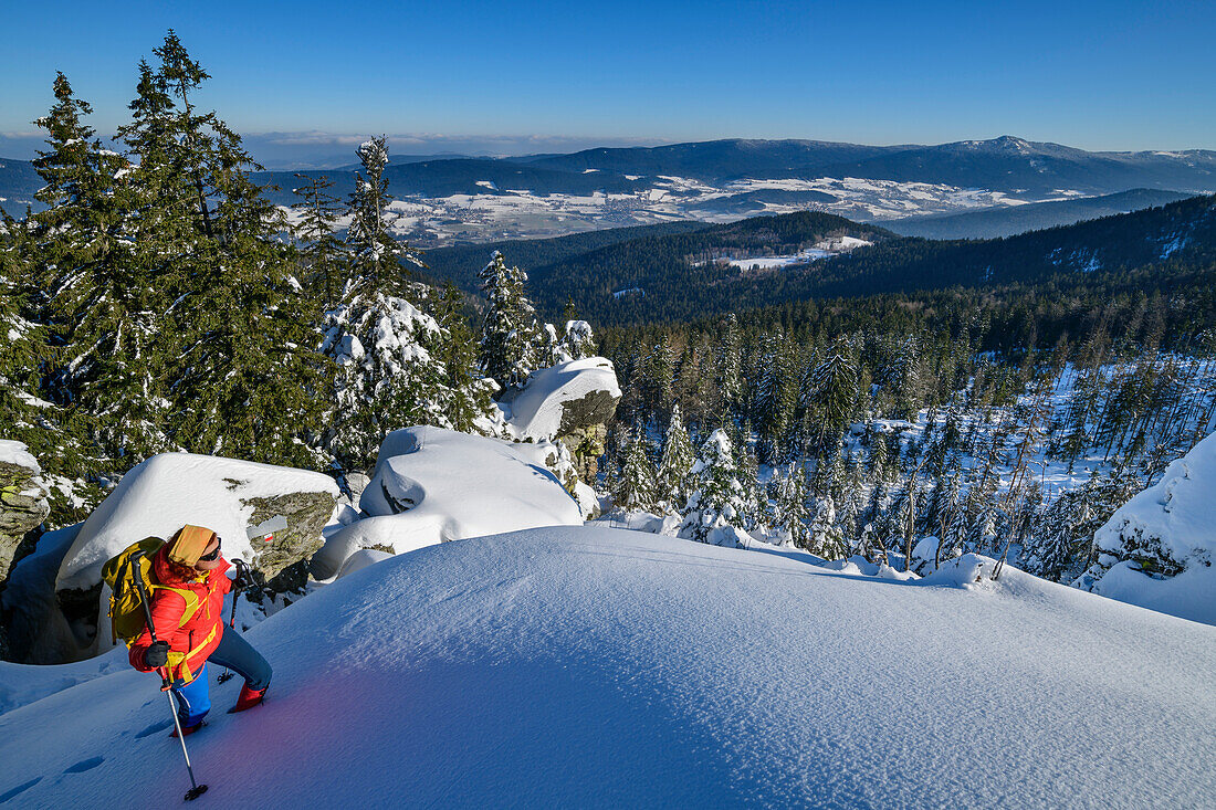 Woman hiking in winter climbs up to the smoke tubes, smoke tubes, Kaitersberg, Bavarian Forest, Lower Bavaria, Bavaria, Germany