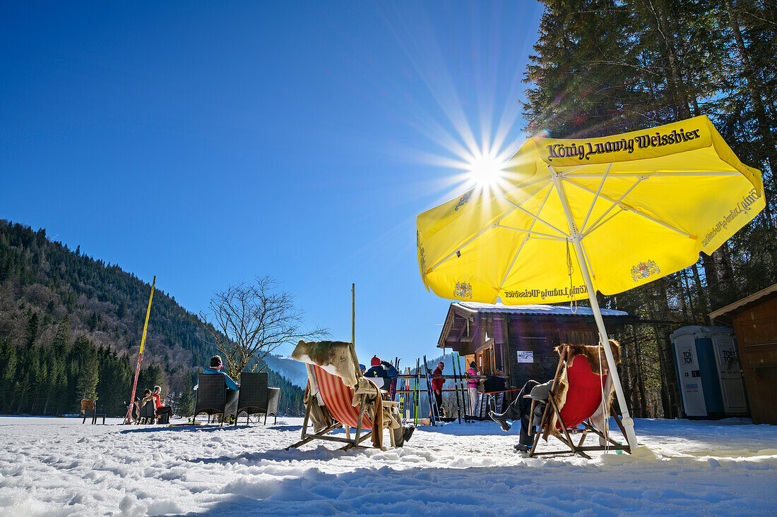 Several people take a break at a small wooden hut, Bayrischzell, Mangfall Mountains, Bavarian Alps, Upper Bavaria, Bavaria, Germany